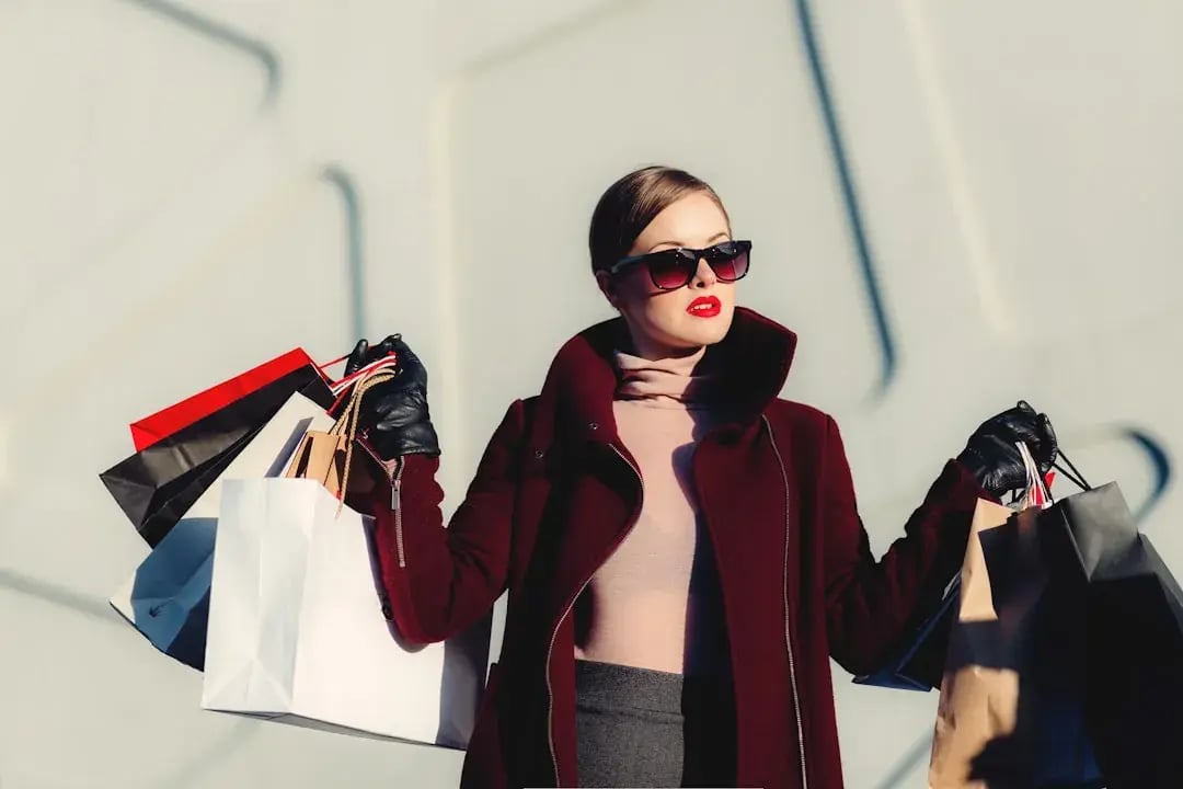 Fashionable woman with shopping bags, symbolizing the impact of Trump’s 2025 tariffs on apparel prices and consumer trends.
